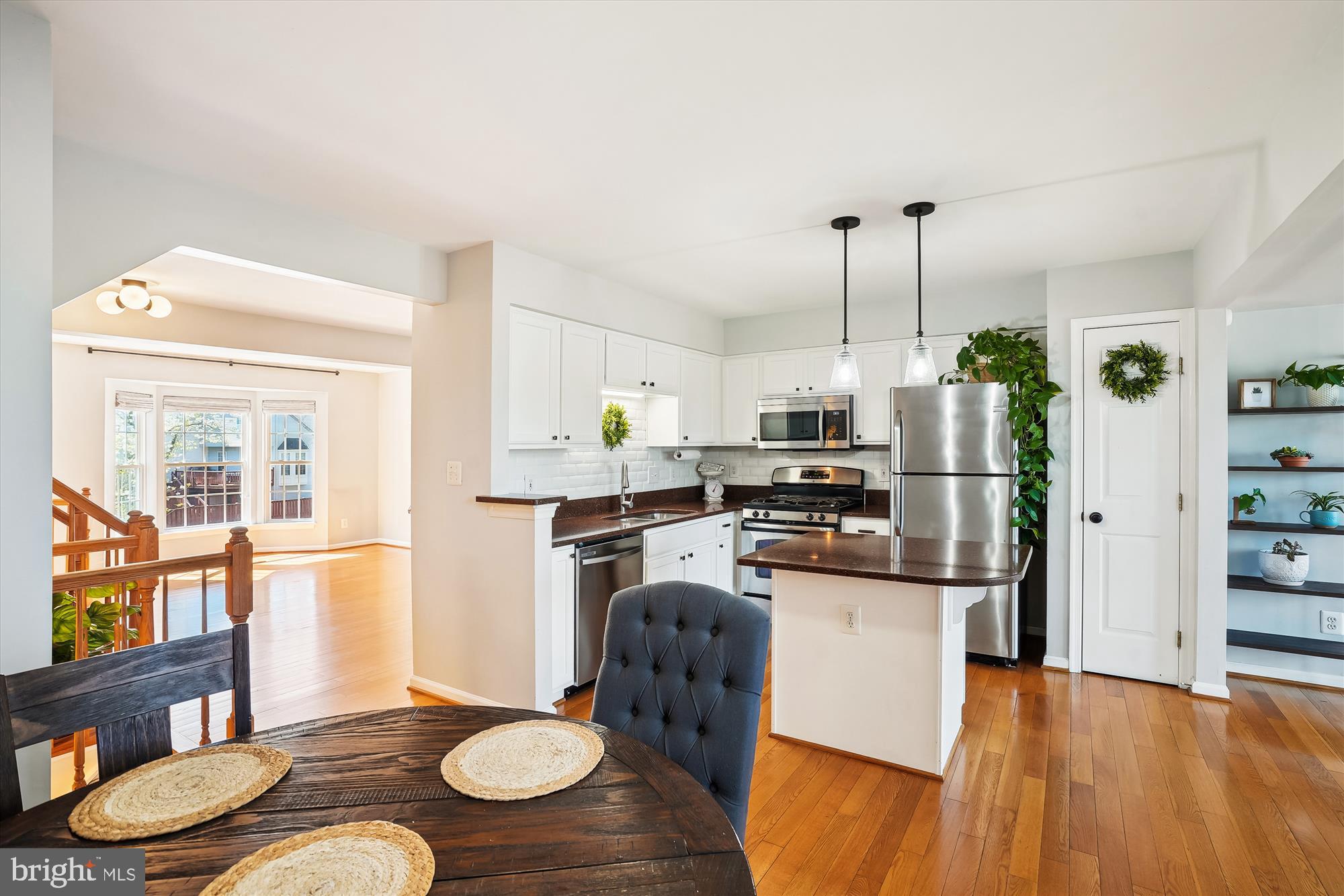 15761 Viewpoint Circle Dumfries, VA 22025 - Photo 13 of 46 a kitchen with stainless steel appliances granite countertop a refrigerator a stove and a dining table with wooden floor
