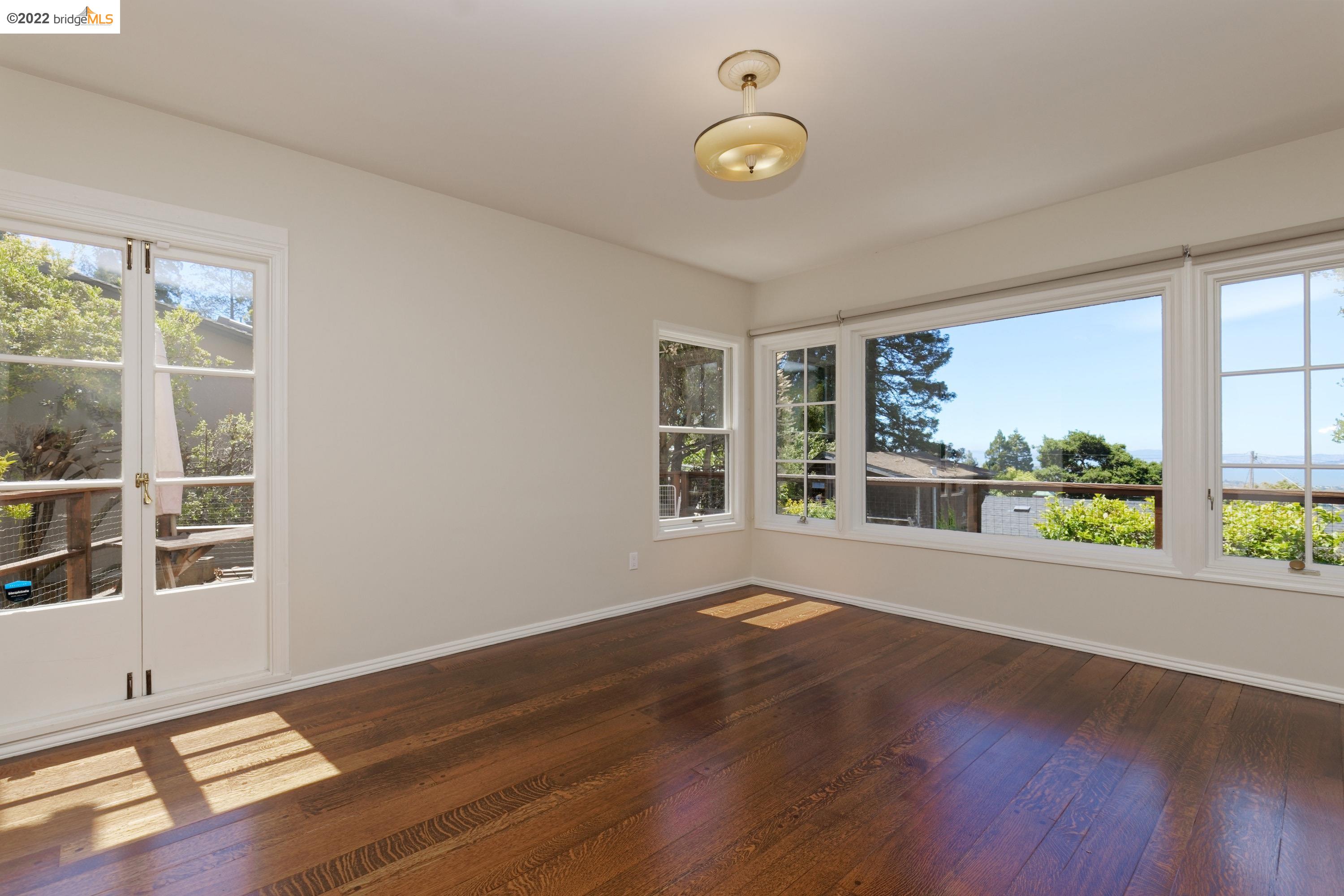 920 Spruce Street Berkeley, CA 94707 - Photo 11 of 36 a view of an empty room with a window and wooden floor