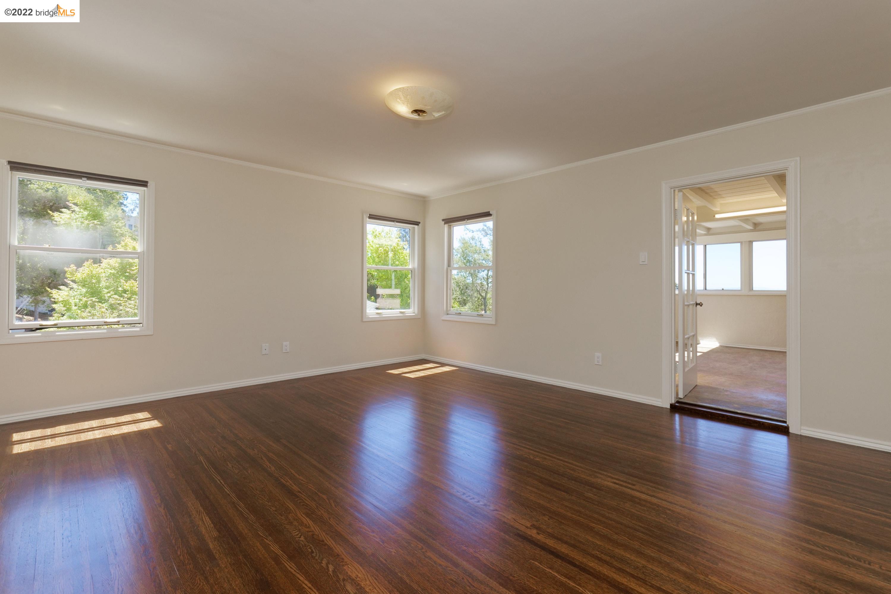 920 Spruce Street Berkeley, CA 94707 - Photo 21 of 36 an empty room with wooden floor and windows
