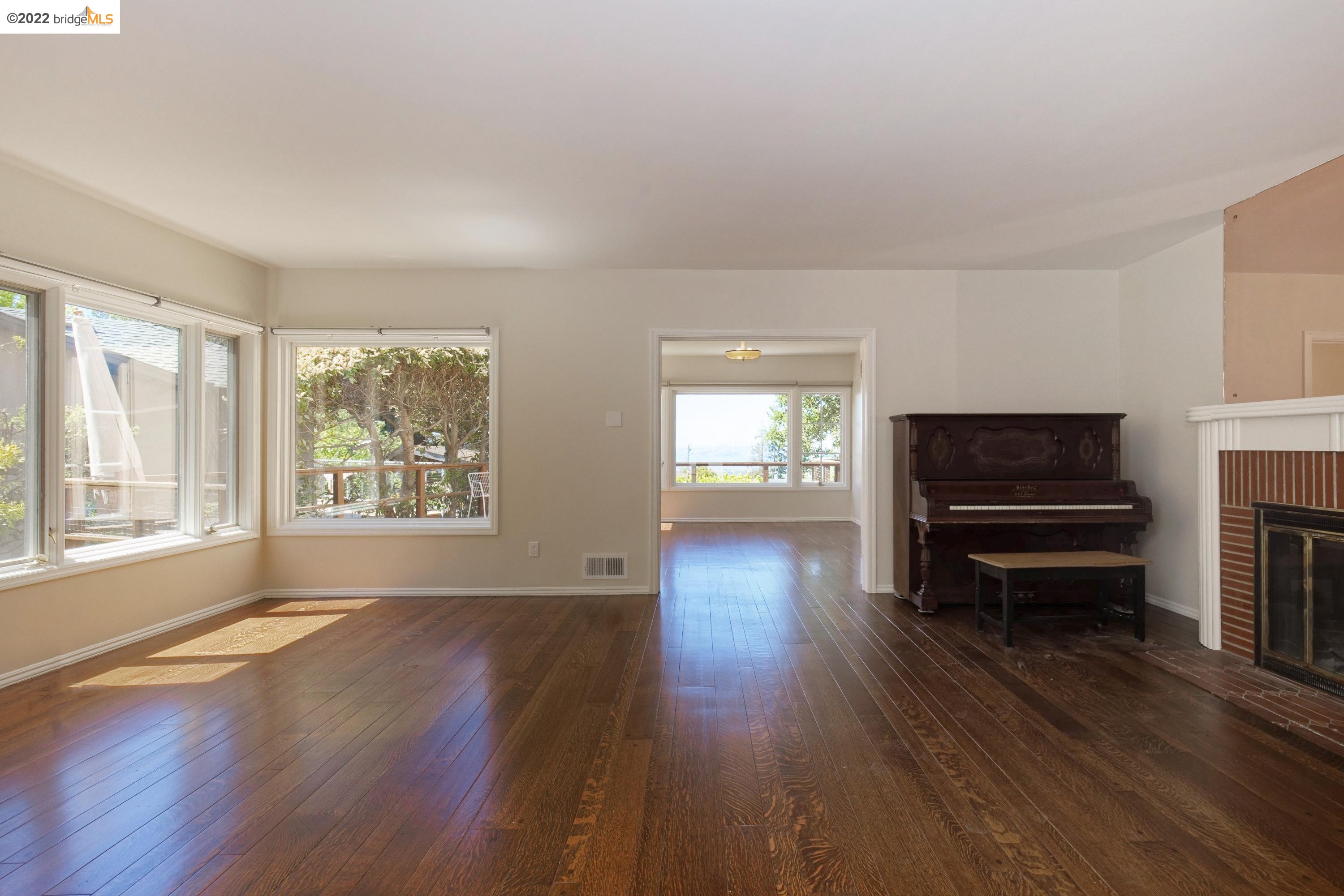 920 Spruce Street Berkeley, CA 94707 - Photo 7 of 36 wooden floor fireplace and windows in an empty room