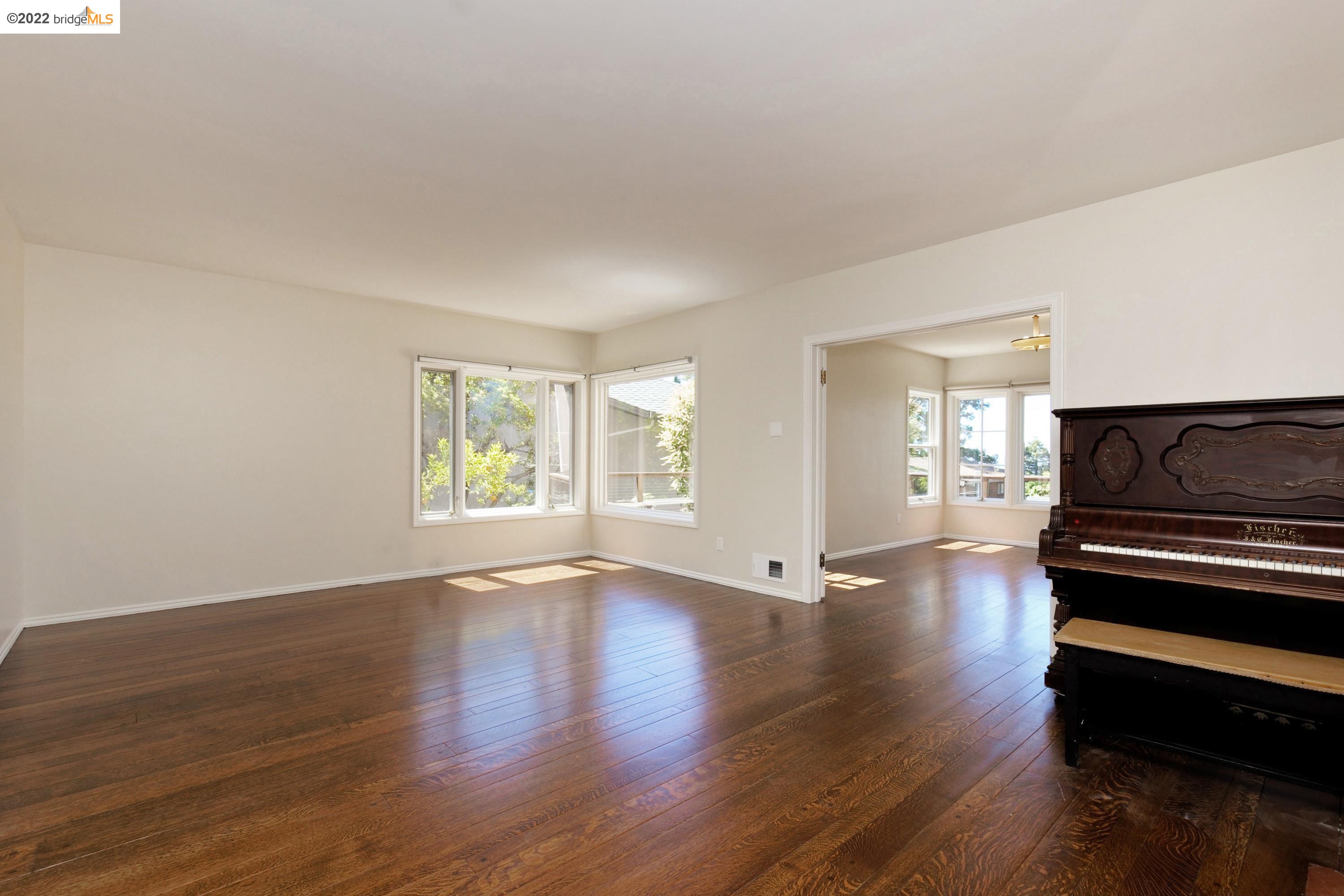 920 Spruce Street Berkeley, CA 94707 - Photo 8 of 36 a view of an empty room with wooden floor and a window