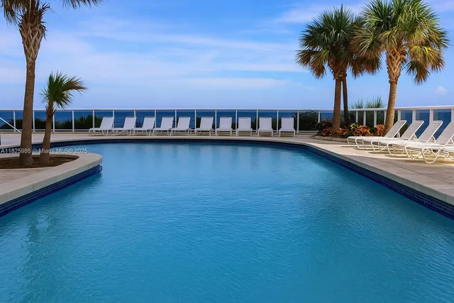 a view of swimming pool with outdoor seating and a garden