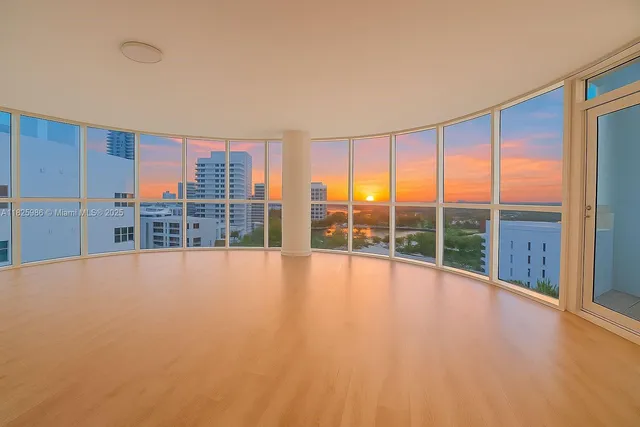 a view of an empty room with a large window with outer view