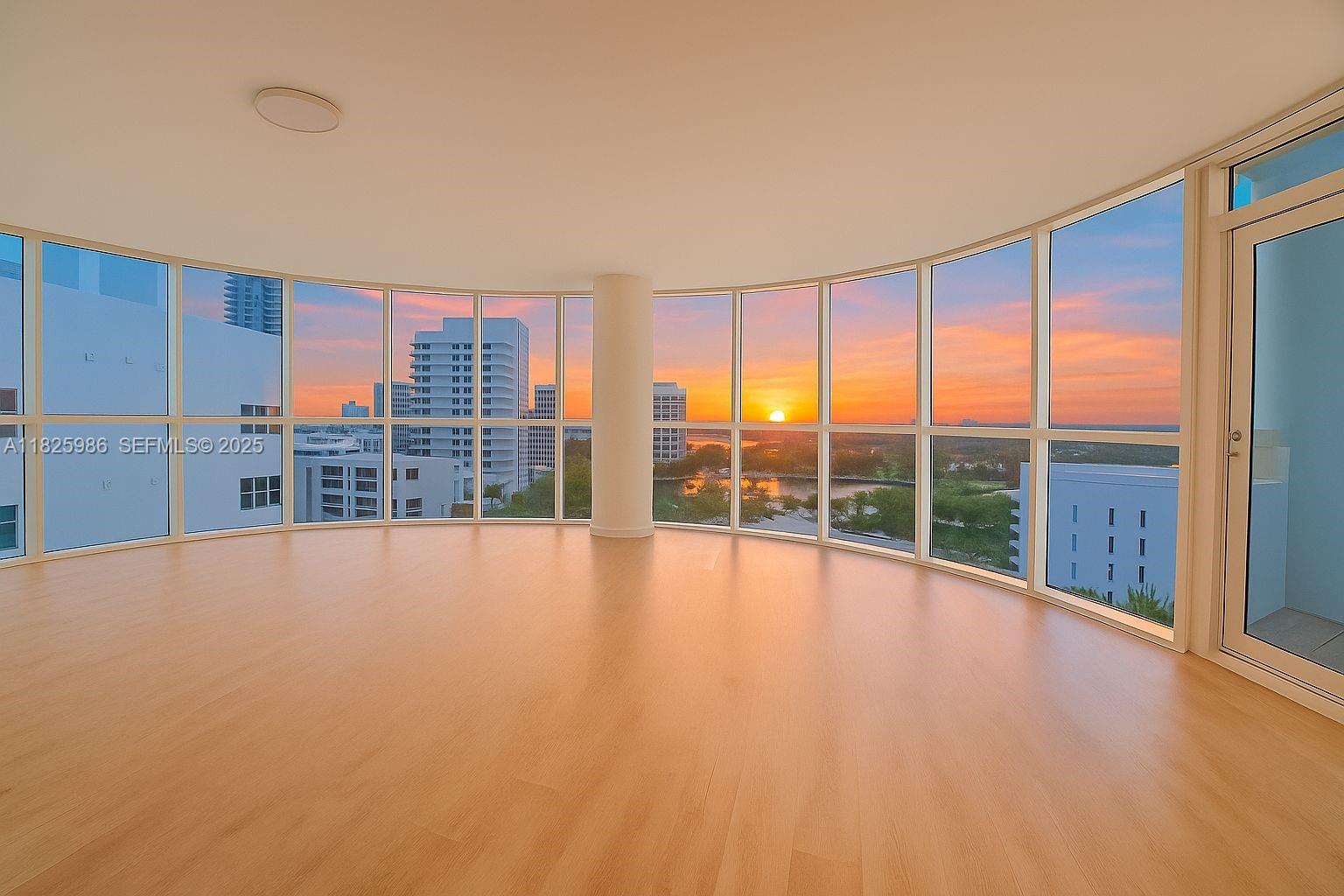 6301 Collins Avenue, Unit 1005 Miami Beach, FL 33141 - Photo 7 of 35 a view of an empty room with a large window and wooden floor