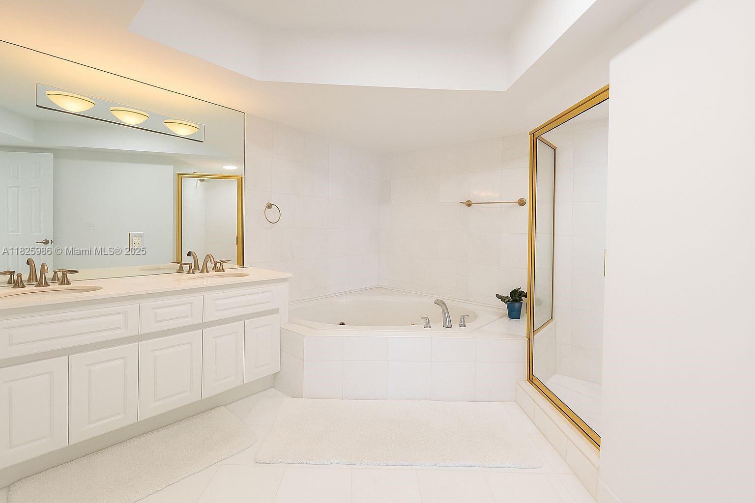 6301 Collins Avenue, Unit 1005 Miami Beach, FL 33141 - Photo 9 of 35 a spacious bathroom with a bathtub sink and mirror