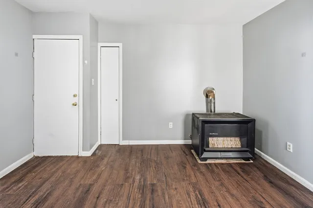 a view of a livingroom with wooden floor and a fireplace