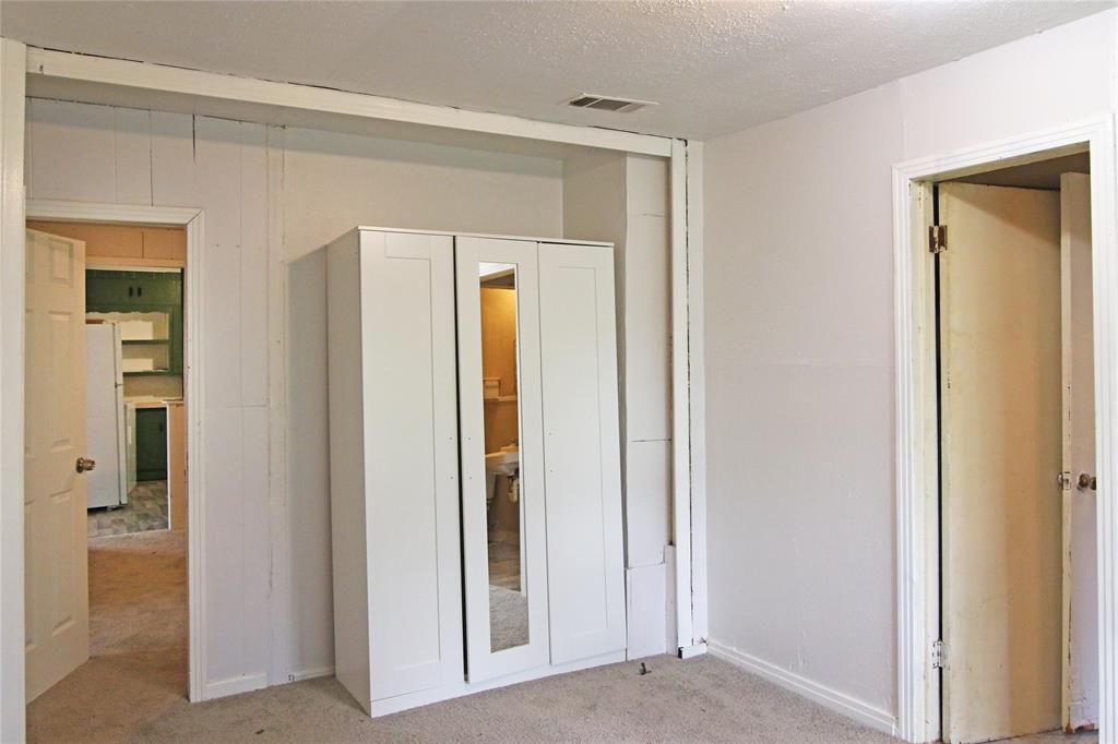 1508 Witt Street Waco, TX 76704 - Photo 22 of 37 Unfurnished bedroom featuring light carpet, freestanding refrigerator, and a textured ceiling