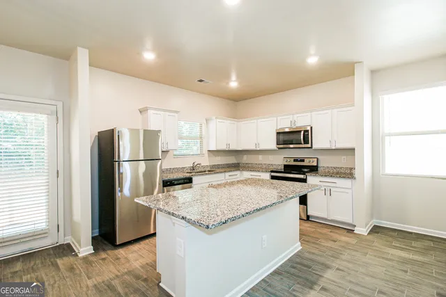 a kitchen with stainless steel appliances granite countertop a refrigerator stove microwave and sink