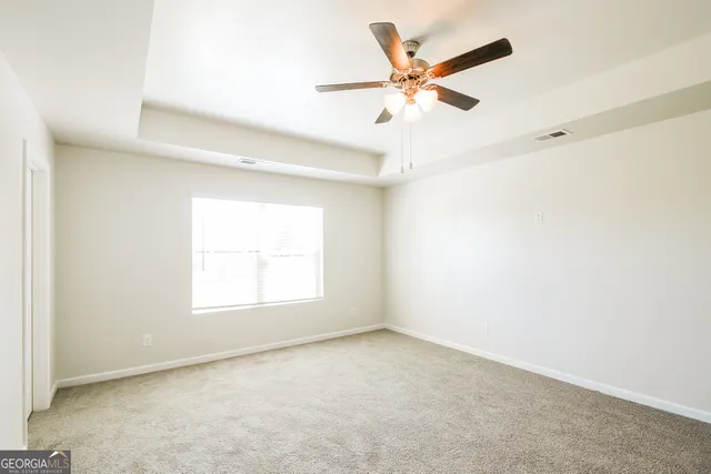 an empty room with a window and a fan
