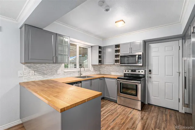 a kitchen with a sink stove and wooden cabinets