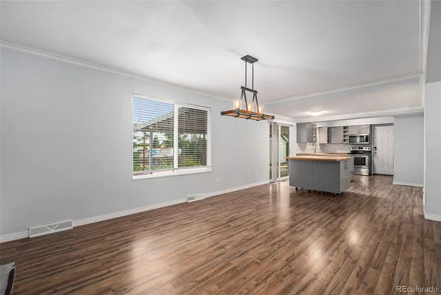 a living room with furniture a chandelier and a window