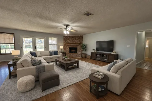 a living room with furniture a fireplace and a flat screen tv