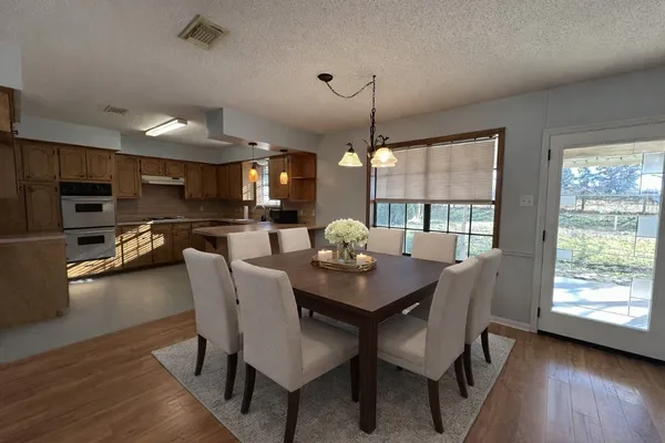a dining room with furniture and wooden floor