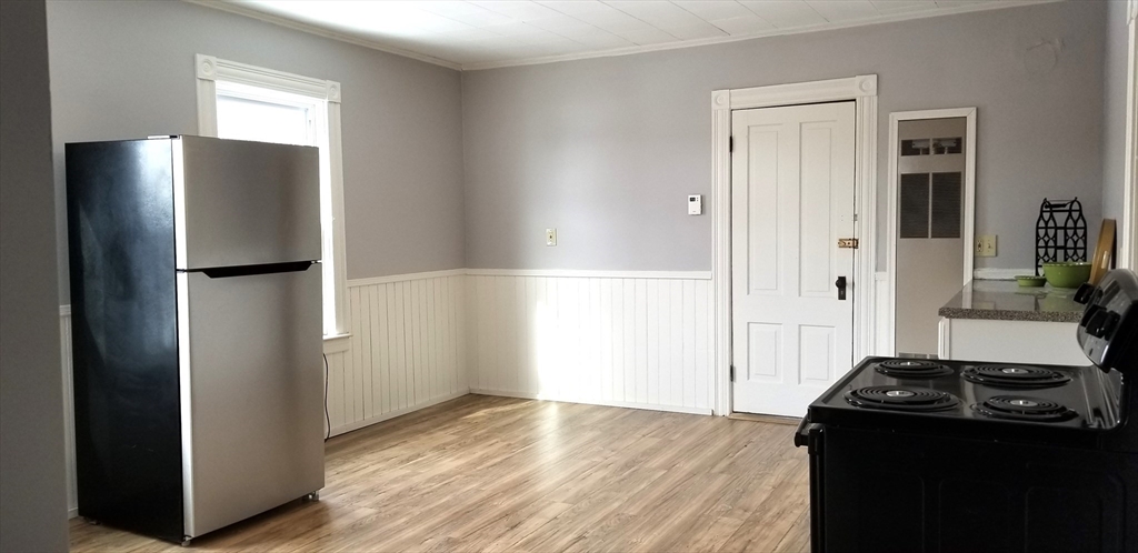 9 Pine Street, Unit 2 Dudley, MA 01571 - Photo 1 of 6 a view of a kitchen with a stove refrigerator and wooden floor