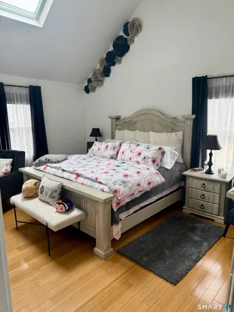 a bed sitting in a bedroom and a flat screen tv