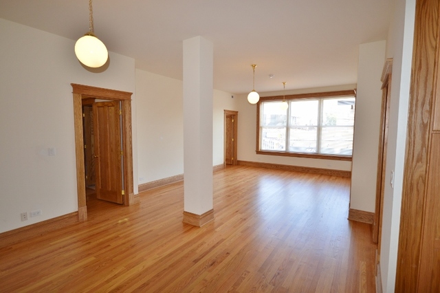 Undisclosed Address Chicago, IL 60657 - Photo 3 of 9 an empty room with wooden floor and windows