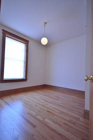 Undisclosed Address Chicago, IL 60657 - Photo 7 of 9 a view of an empty room with wooden floor and a window