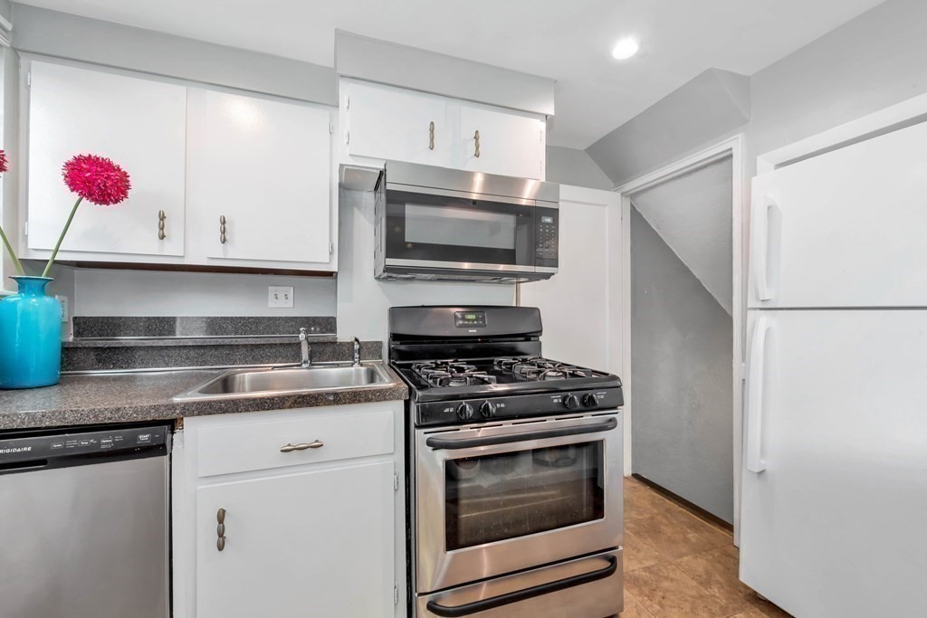 18 Pierce Road, Unit 18 Watertown, MA 02472 - Photo 11 of 38 a kitchen with granite countertop cabinets stainless steel appliances and wooden floor