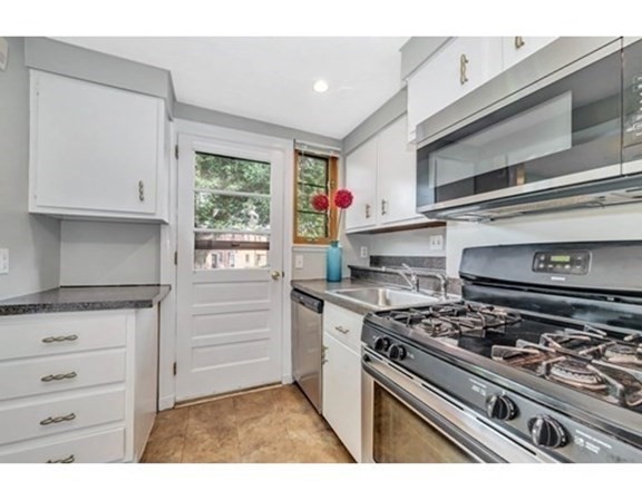 18 Pierce Road, Unit 18 Watertown, MA 02472 - Photo 24 of 38 a kitchen with a stove and white cabinets