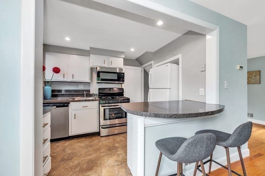 18 Pierce Road, Unit 18 Watertown, MA 02472 - Photo 8 of 38 a kitchen with stainless steel appliances granite countertop a stove a sink and a refrigerator