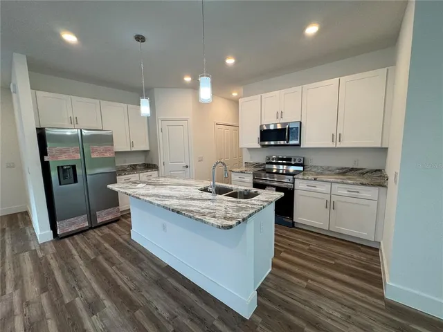 a kitchen with granite countertop white cabinets and black appliances