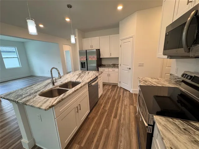 a kitchen with stainless steel appliances granite countertop a stove a sink and a refrigerator
