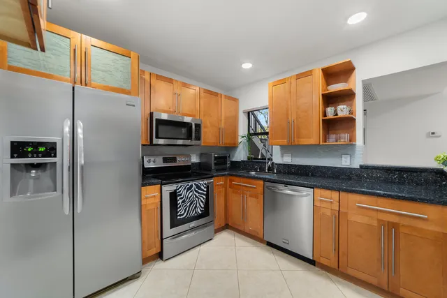 a kitchen with stainless steel appliances granite countertop a refrigerator and a stove top oven