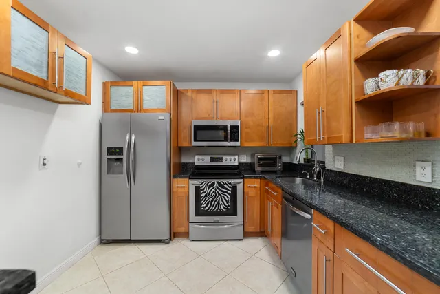 a kitchen with stainless steel appliances granite countertop a refrigerator and a stove
