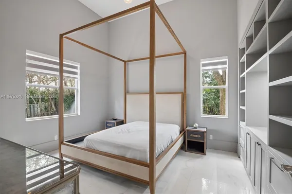 a bedroom with a bed and a flat tv screen on the dresser