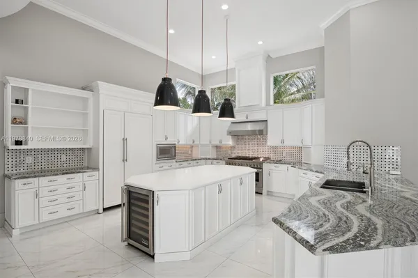 a large kitchen with stainless steel appliances kitchen island granite countertop a sink and cabinets