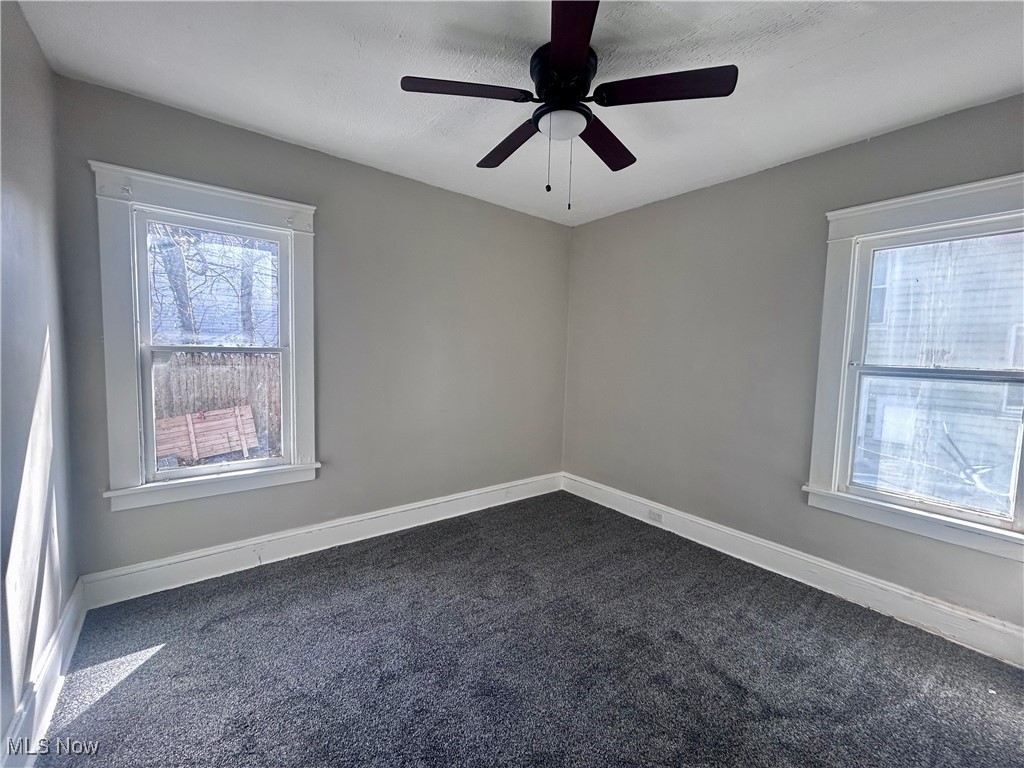 13412 Graham Road Cleveland, OH 44112 - Photo 7 of 18 Spare room with dark colored carpet, a ceiling fan, and baseboards