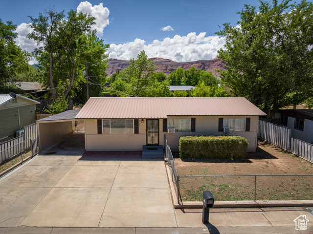 527 Palisade Drive Moab, UT 84532 - Photo 20 of 51 Ranch-style house featuring metal roof, concrete driveway, a mountain view, and an attached carport