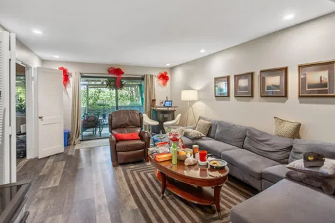 a living room with furniture and a wooden floor