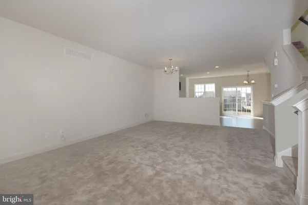 an empty room with a kitchen area and painted walls
