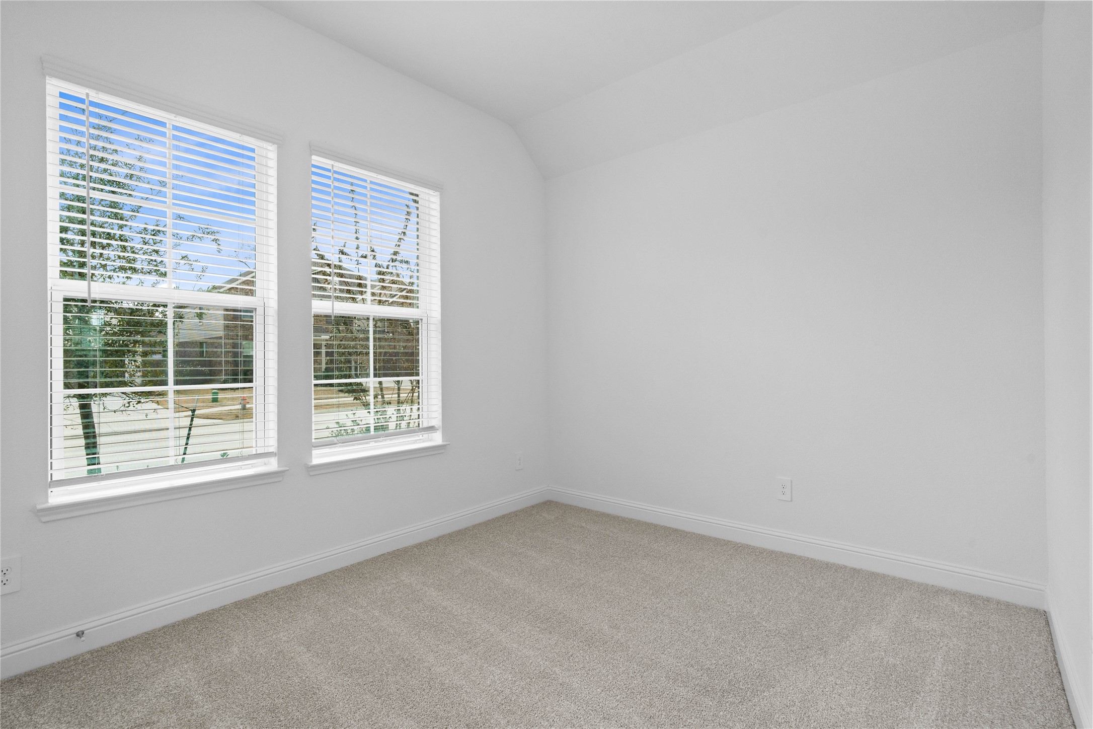 17315 July Moon Lane Conroe, TX 77302 - Photo 9 of 46 Tucked peacefully in the front of the home is this guest suite, which offers a bright layout with neutral finishes and natural light. Featuring plush carpeting, large windows with blinds, and an en-suite secondary bathroom.