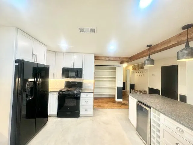 a kitchen with granite countertop a refrigerator and a sink