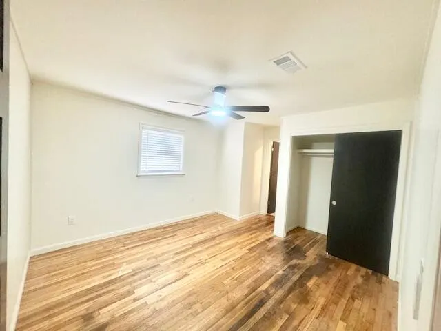 a view of a big room with wooden floor and windows in a room