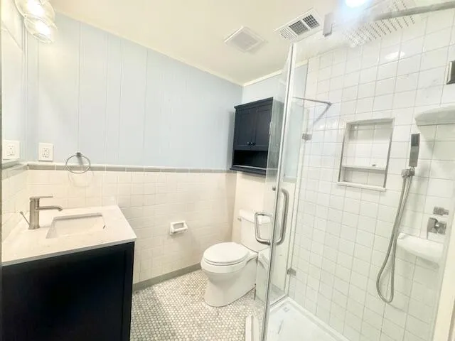 a bathroom with a sink a toilet and shower
