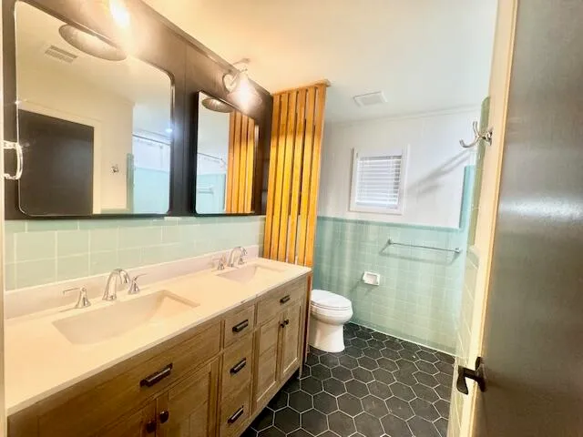 a bathroom with a double vanity sink mirror and toilet