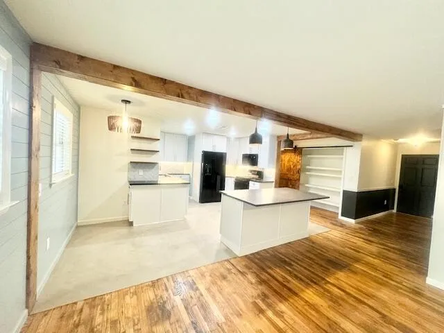 a large white kitchen with kitchen island a sink stainless steel appliances and cabinets