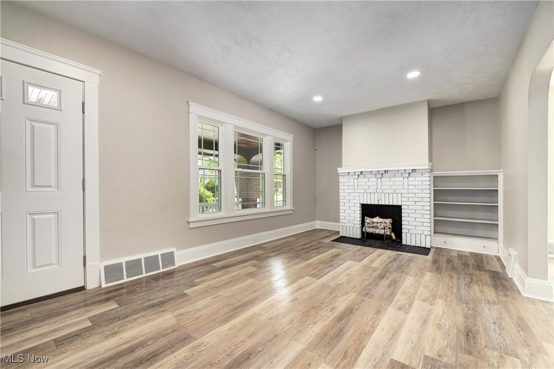 896 Selwyn Road Cleveland Heights, OH 44112 - Photo 4 of 23 Unfurnished living room featuring wood finished floors, recessed lighting, and a brick fireplace