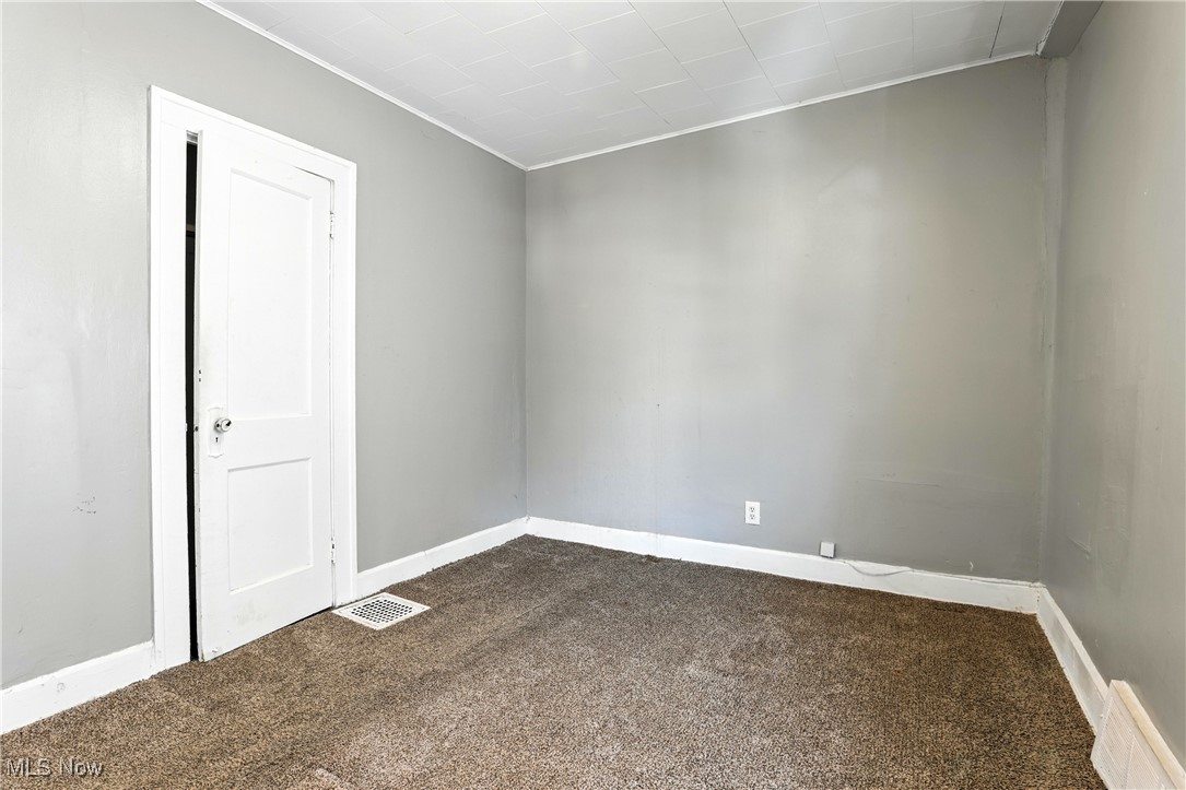 1774 Urbana Road Cleveland, OH 44112 - Photo 29 of 41 Empty room with dark carpet and crown molding