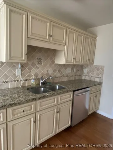 a kitchen with granite countertop white cabinets and a sink