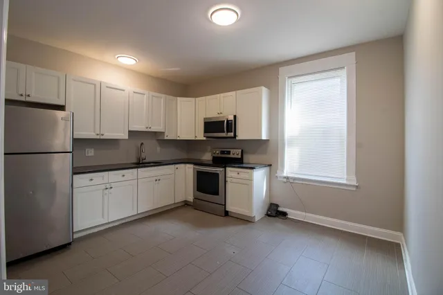 a kitchen with granite countertop white cabinets and stainless steel appliances