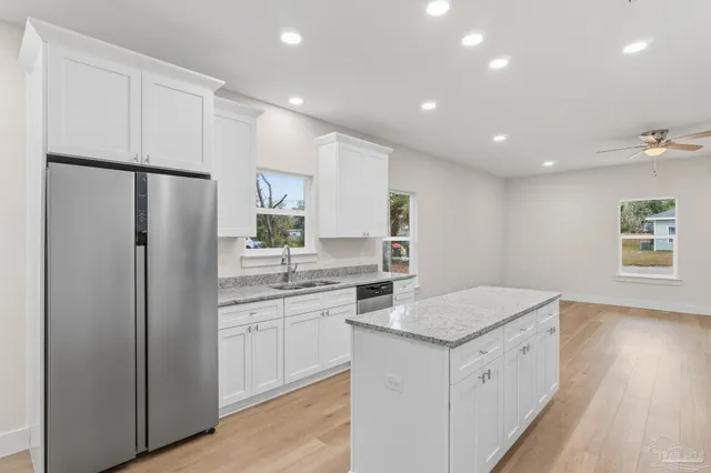 a kitchen with white cabinets and refrigerator