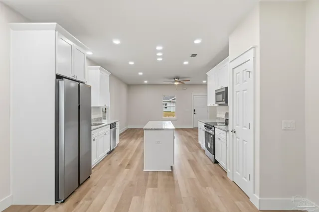 a kitchen with white cabinets and stainless steel appliances
