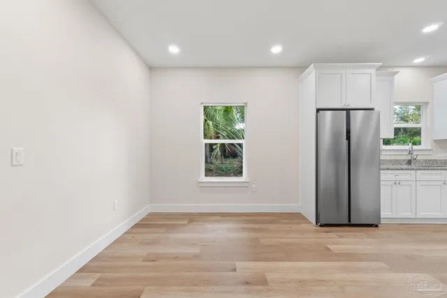 a view of a kitchen with a refrigerator a microwave and a sink