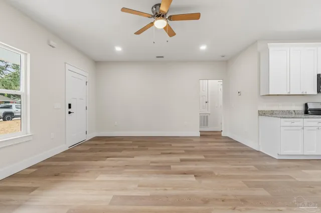 a view of empty room with window and a ceiling fan