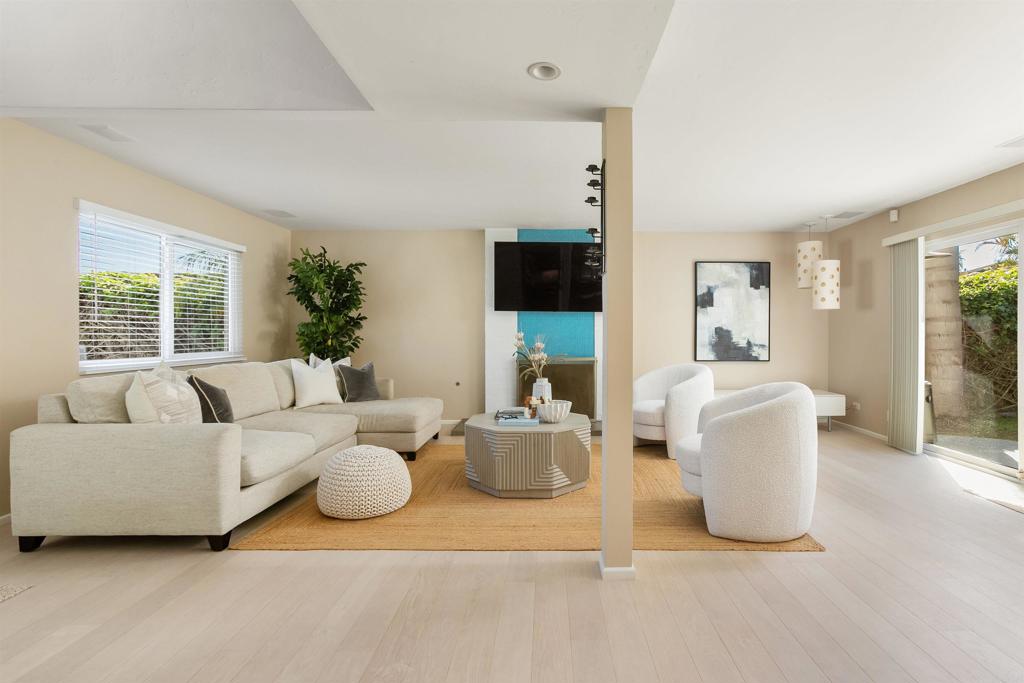 a living room with furniture a flat screen tv and a large window