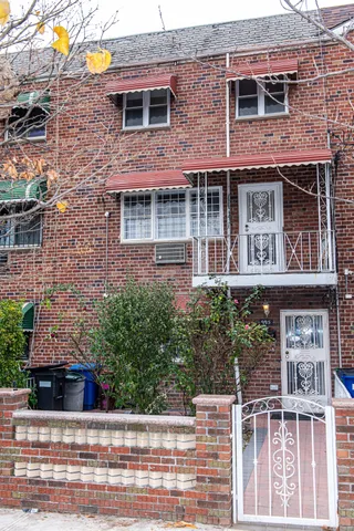 front view of a brick house with a small yard